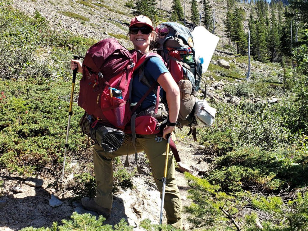 girl hiking with two backpacks