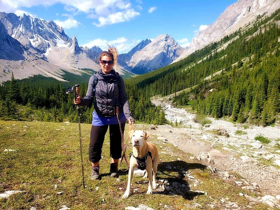 girl in mountains hiking with dog